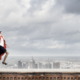 Business person in superhero pose overlooking a cityscape, symbolizing the strength and flexibility of cloud infrastructure to support and elevate businesses in dynamic environments.